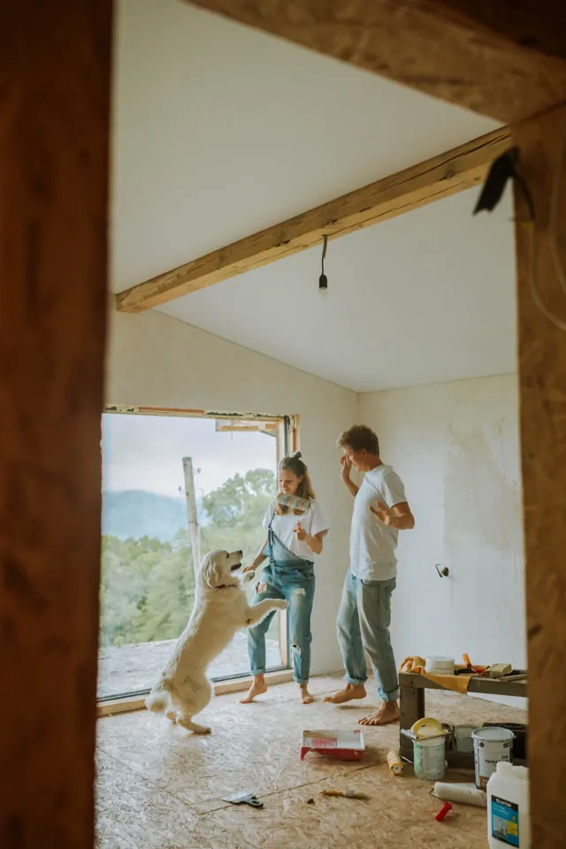 A couple and their dog in a home being renovated