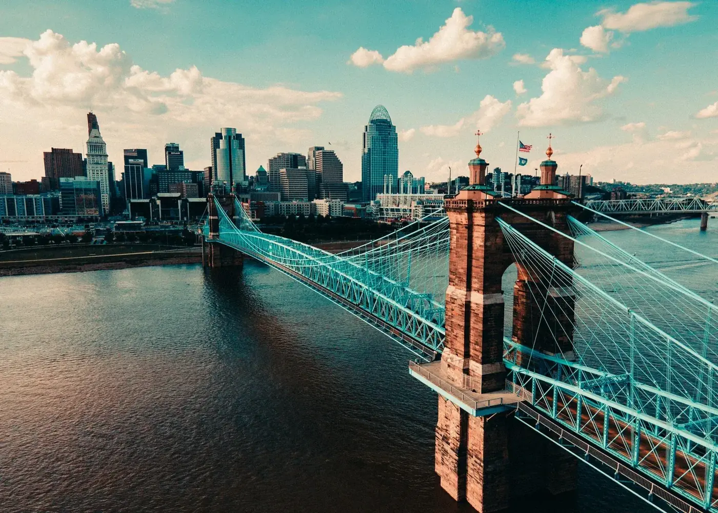 City skyline with suspension bridge over a river